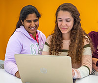 Prospective undergraduate students use a laptop to research University of Akron degree programs.
