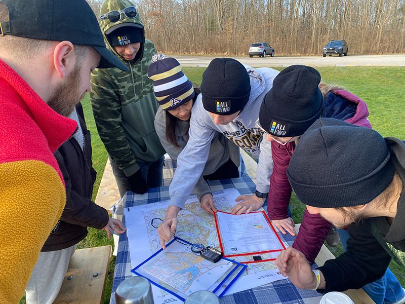 Participants working together at a table outside during a navigation experience.