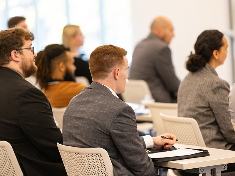 Participants sitting in a classroom listening to a class.