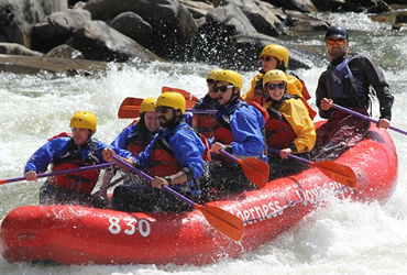 a group of students whitewater rafting in down a river