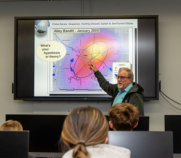 University of Akron professor explains crime pattern analysis on a digital map to students in a criminal justice class.