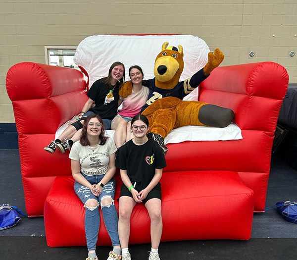 Students sitting with Zippy in an oversized inflated chair