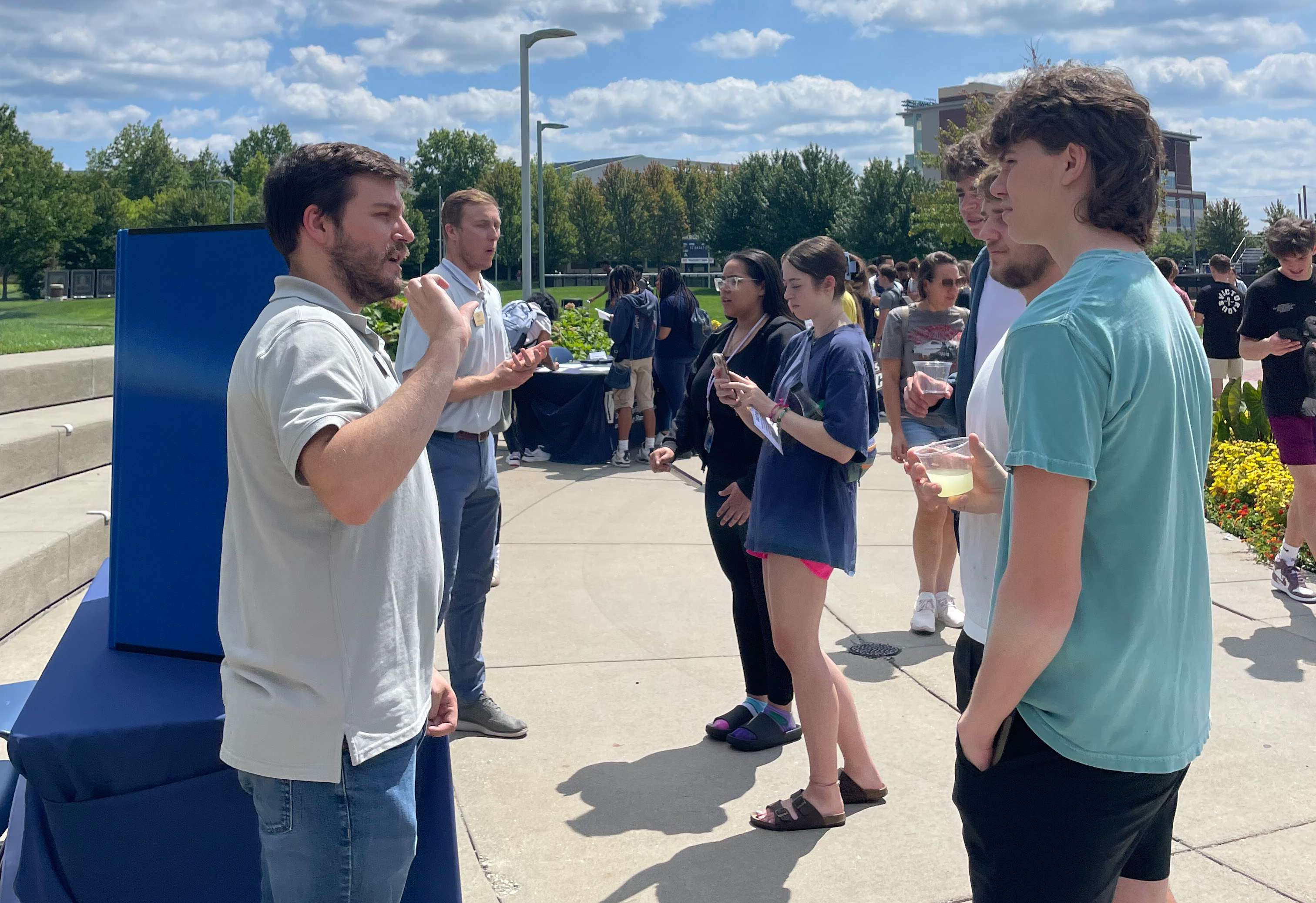 Image of a UA staff member speaking with students at an event.