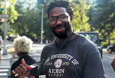 African-American communication alumnus filming on campus.