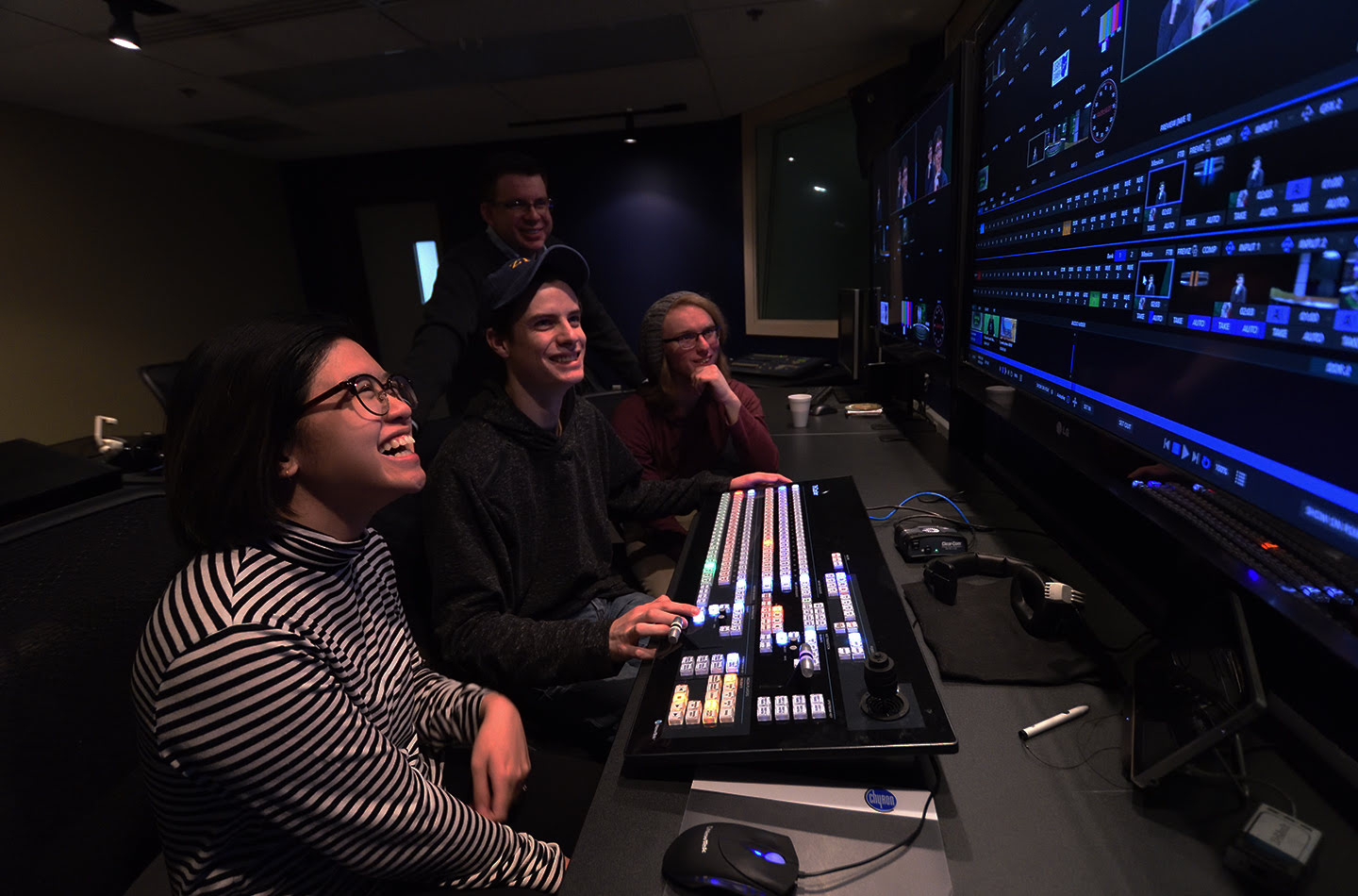 Two students and a professor working at a soundboard