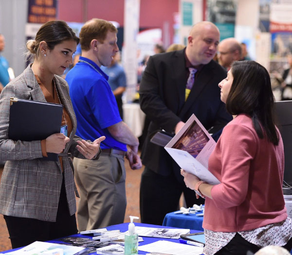 University of Akron student speaks with an employer at a career fair, exploring internship and job opportunities.