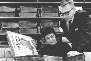 Black and white vintage photograph of Dr. Knepper and a woman look at a book in the University of Akron Archives.