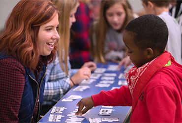 University of Akron education student works with a young student on a hands-on classroom activity.