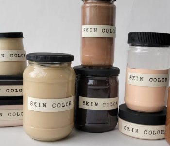 Jars of paint all labeled Skin Color, reflecting various skin tones