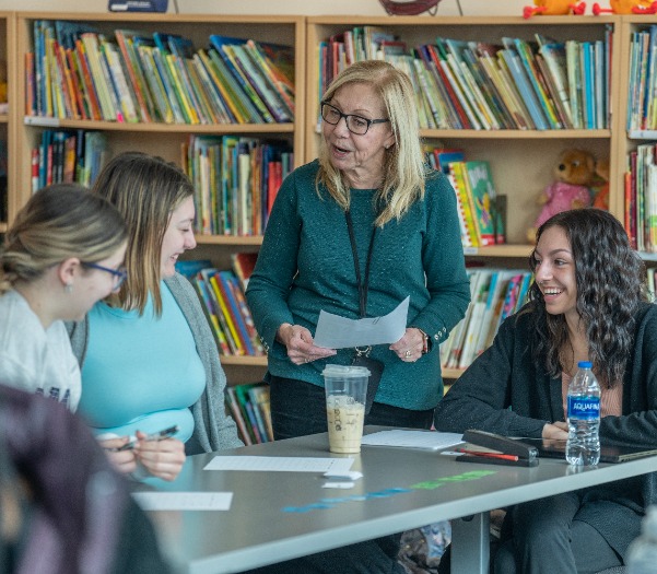 Advisor going over schedule with group of students in library