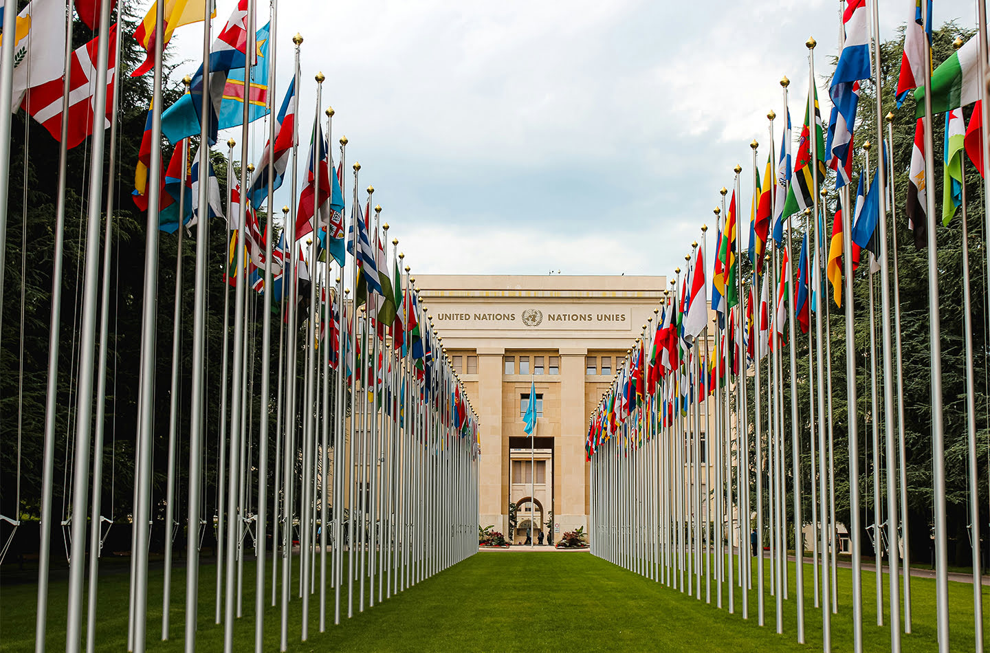 A view of the United Nations building through a row of flags from various countries