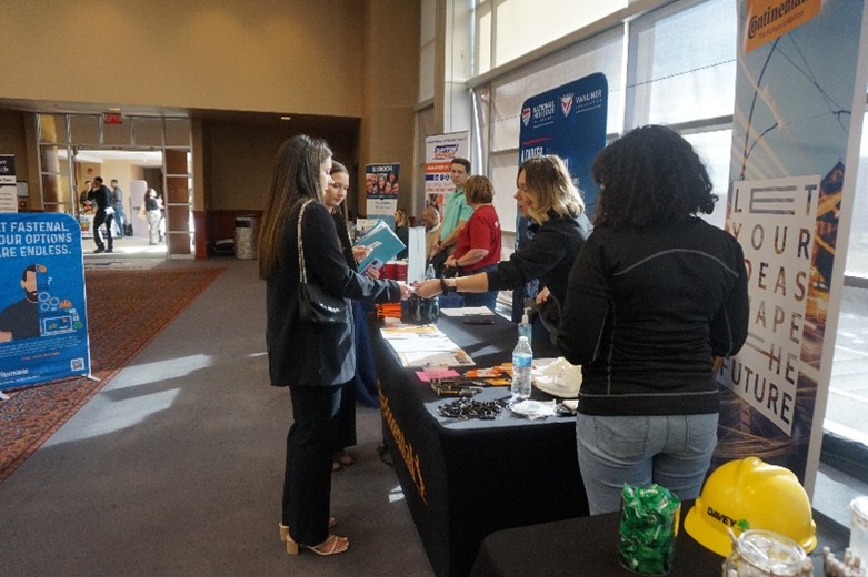 Image of students talking with employers tabling at a career fair