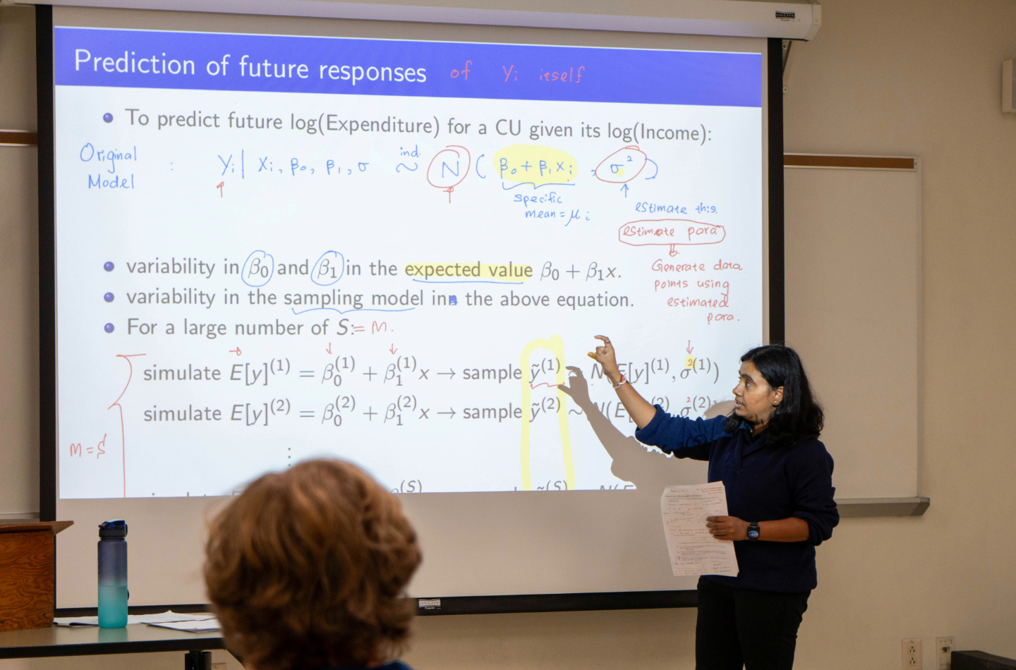 Faculty member in front of white board teaching class