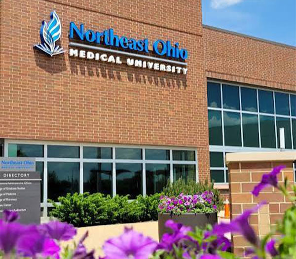 Exterior of Northeast Ohio Medical University (NEOMED) campus building with the university's name displayed above the entrance.
