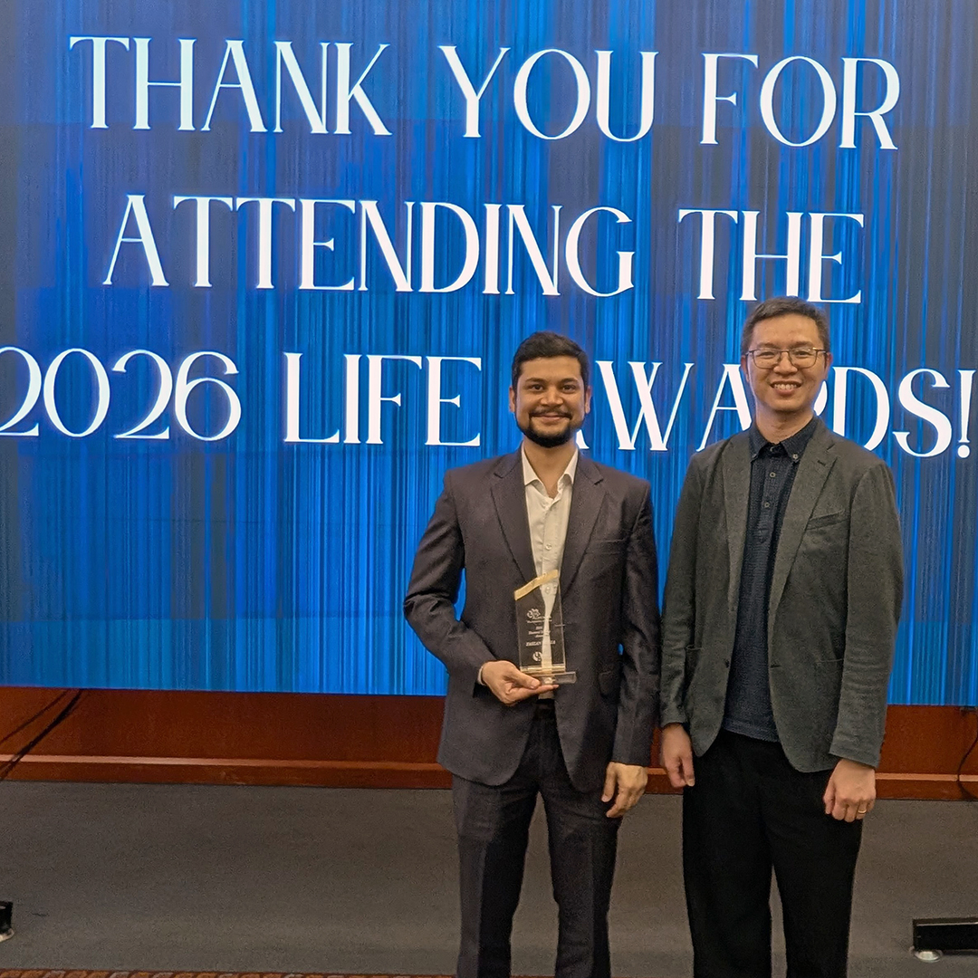 Faizan Mirza and Dr. K.T. Tan pose for a photo as Mirza holds his LIFE Award recognizing doctoral student achievement.