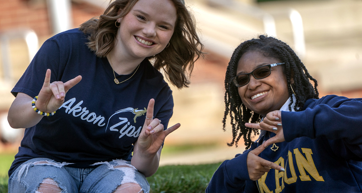 UA students on campus showing zips finger sign