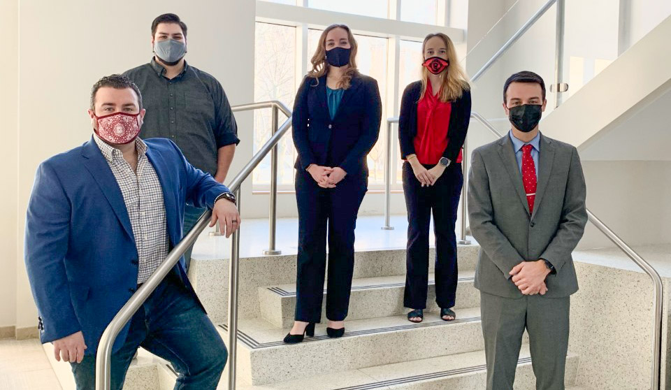 Members of the high performing 2021 Akron Law Trial Team stand on steps inside the School of Law.