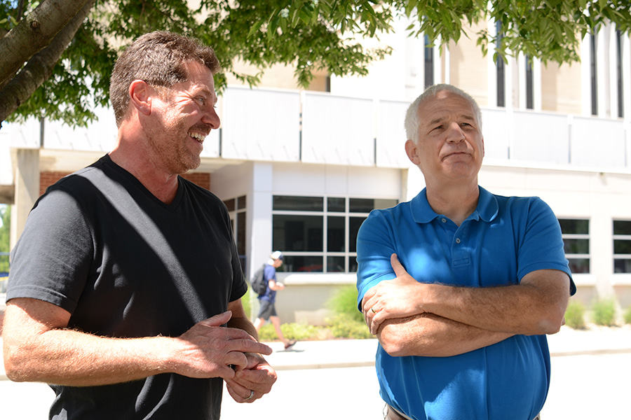 Two men on UA campus on a sunny day.