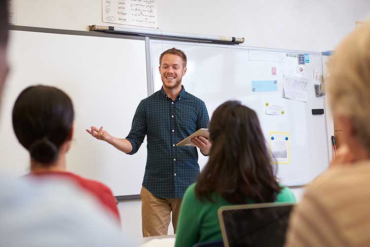 Faculty standing in front of class teaching