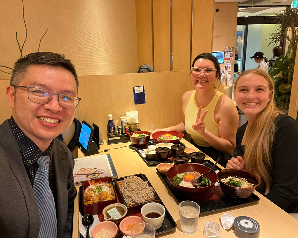 KT Tan, Nanami Whitman and Emily Berdis eating a meal.