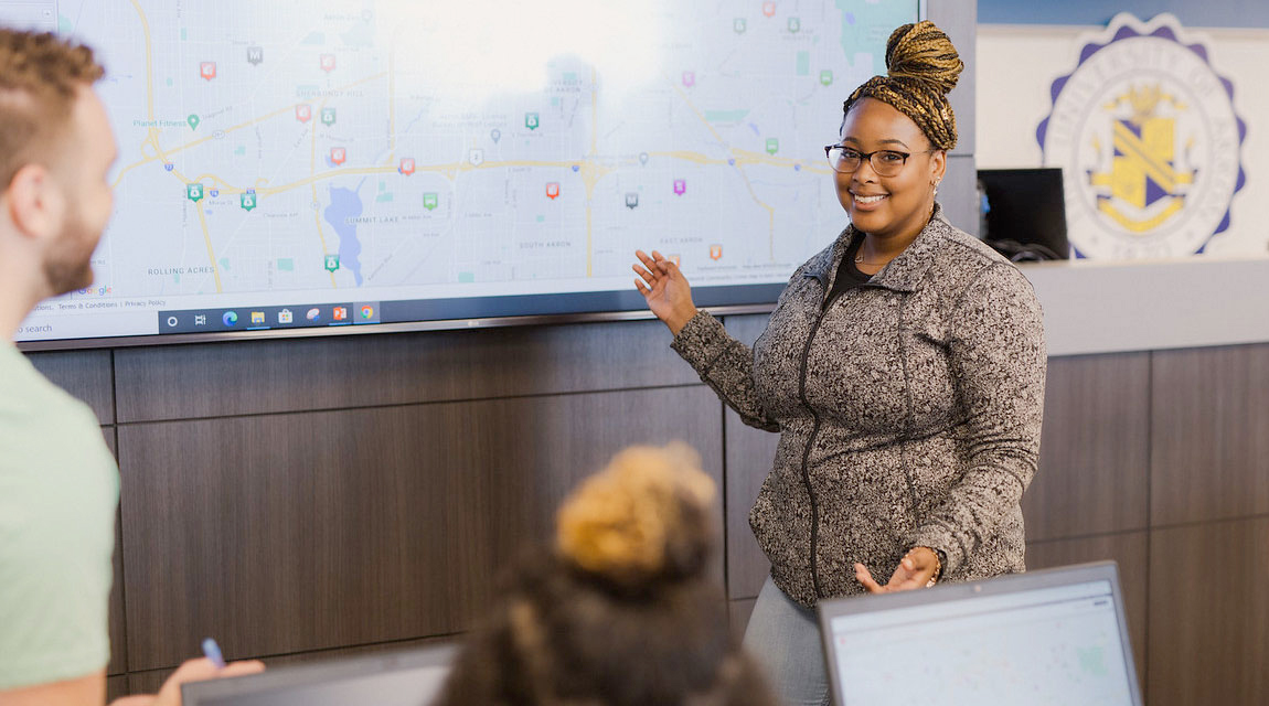 A communication professor talks with students in class